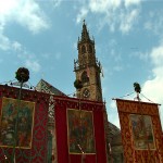 Turm mit Vordergrund Fahnen "Herz-Jesus-Prozession"